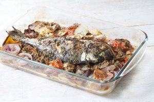 ψάρι στο φούρνο με πατάτες κρεμμυδια και ντοματα