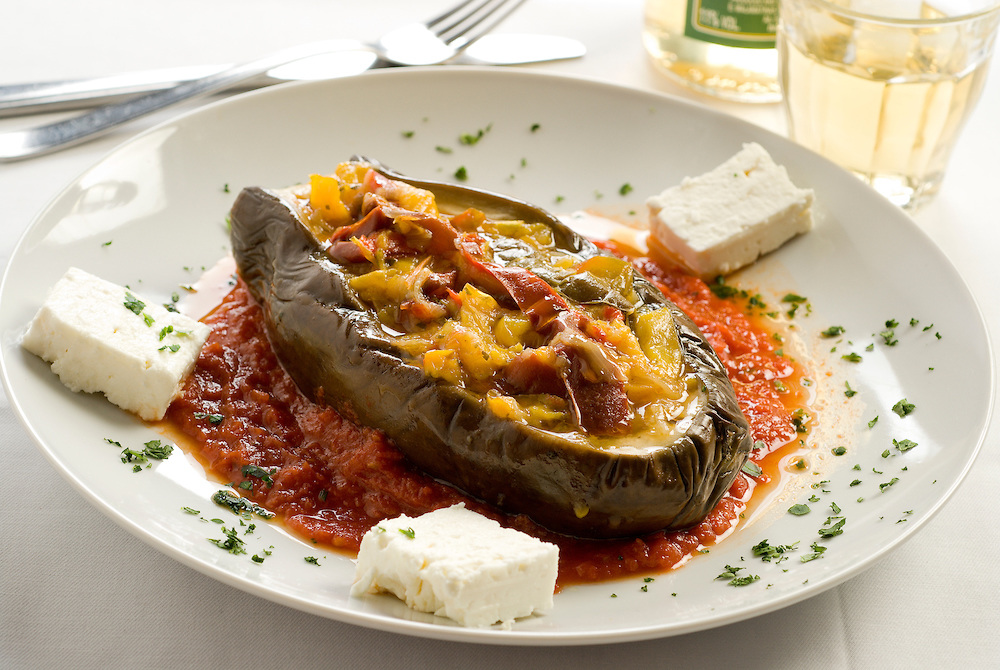 imam baildi, stuffed and stewed eggplant served with tomato sauce and feta cheese and persil